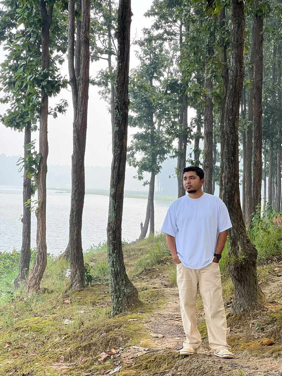 Rajesh Kumar by a lake among trees